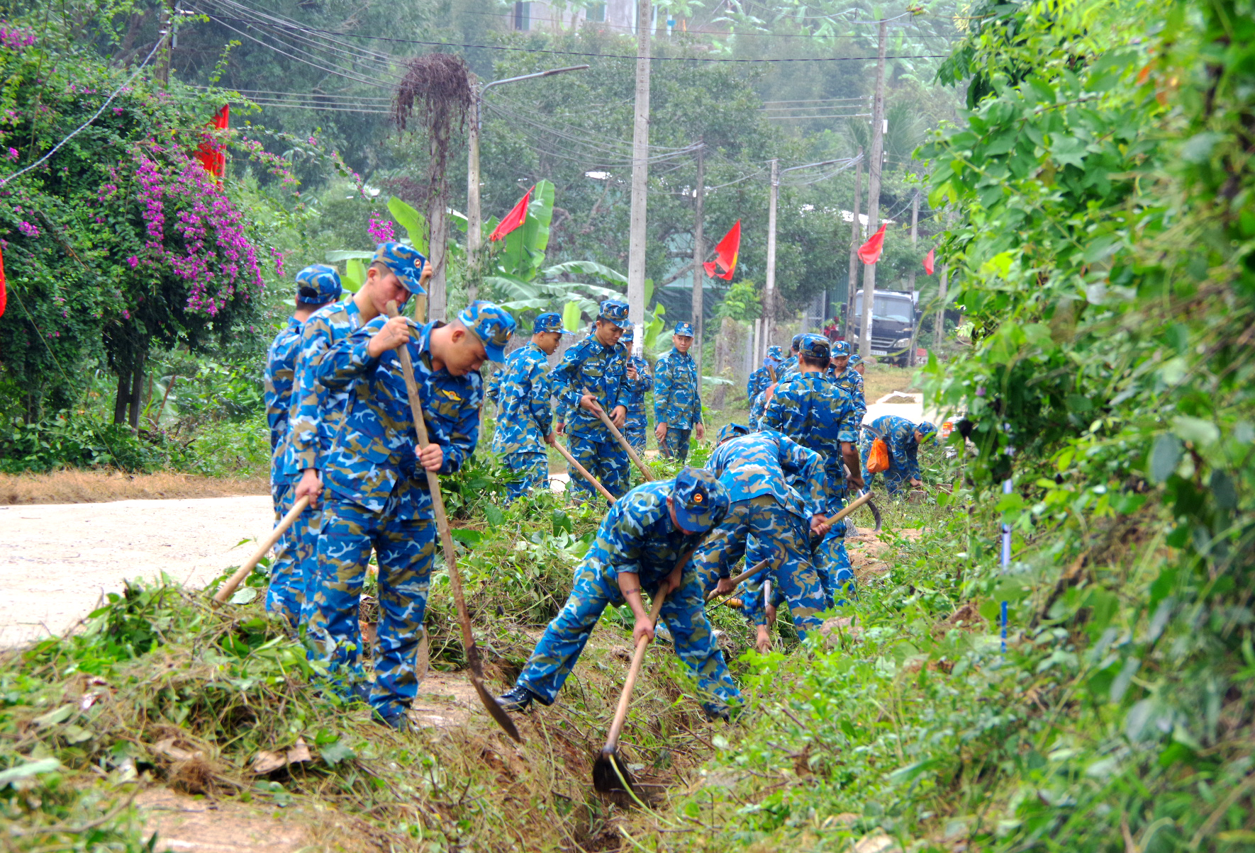 Cán bộ, chiến sĩ tổ chức khơi thông cống rãnh, vệ sinh môi trường tại xã Sơn Tân.