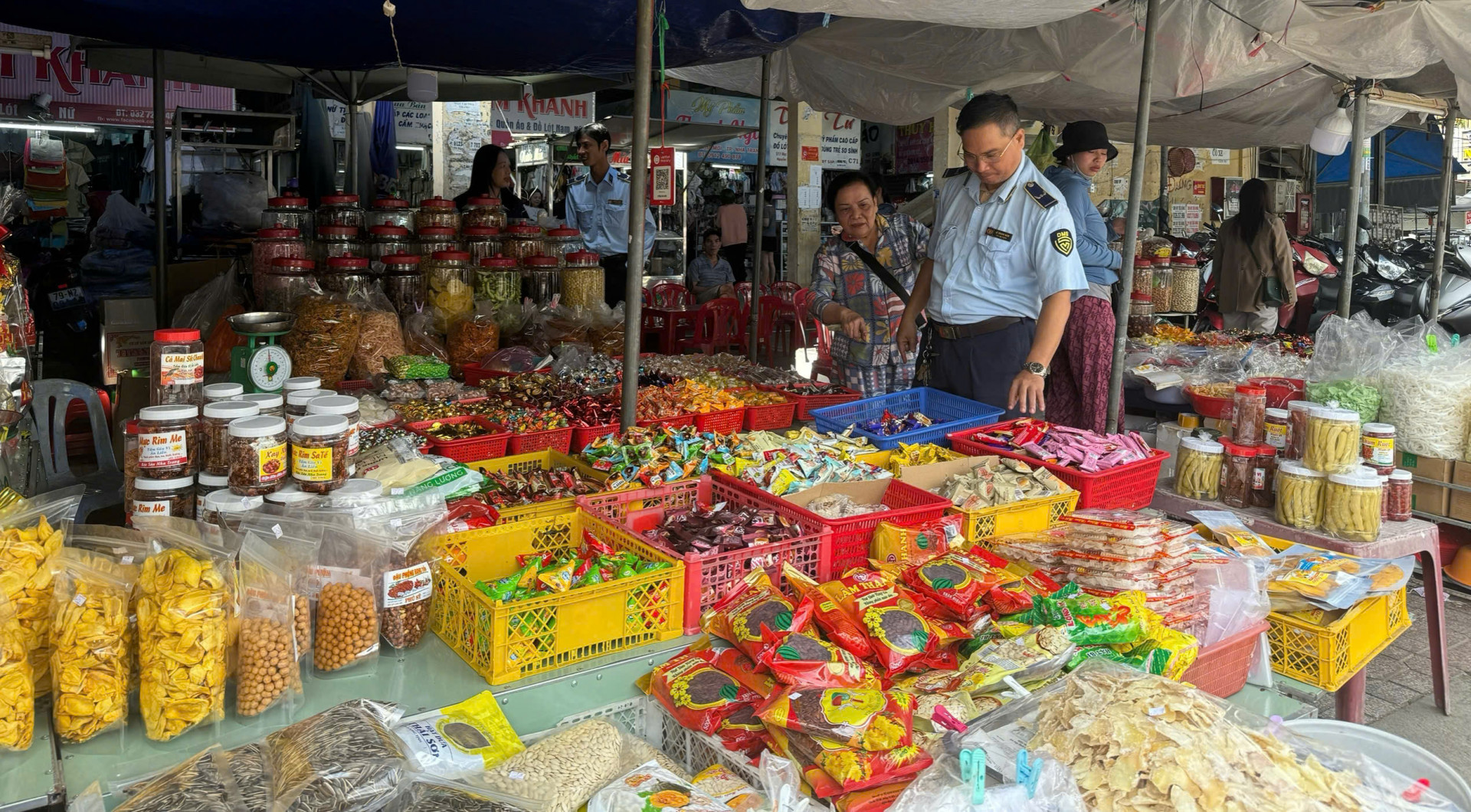 Lực lượng quản lý thị trường kiểm tra, kiểm soát sản phẩm bánh kẹo Tết tại chợ Xóm Mới.